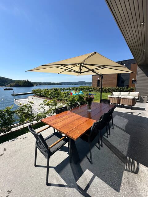 Modern cabin by the lake, driveway in front, with boat dock