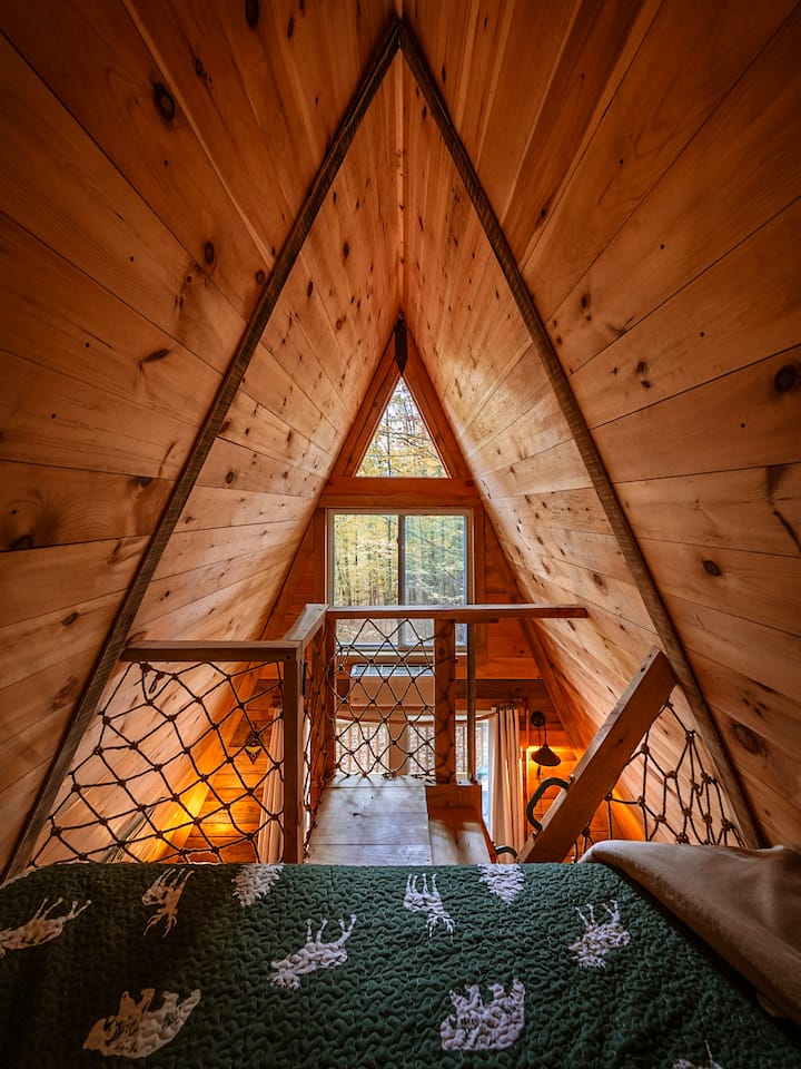 The King Bed loft offers a delightful, elevated vantage point to begin or end your day. As you stretch out, you'll be treated to a captivating view of the surrounding forest. Photo by Chris & Pam Daniele