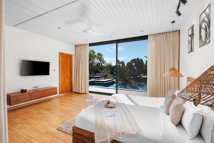 Събудете се на слънце в нашето уютно място на приземния етаж. Тази стая с топли дървени подове и луксозно двойно легло (king size) предлага безпроблемна връзка с природата чрез масивни плъзгащи се стъклени врати, които водят директно към вътрешния двор