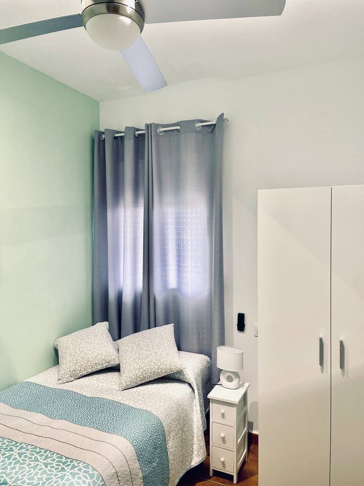 ห้องนอนพร้อมเตียงขนาด 1.05 มีตู้เสื้อผ้าตู้เสื้อผ้าโต๊ะข้างเตียงและพัดลมเพดาน