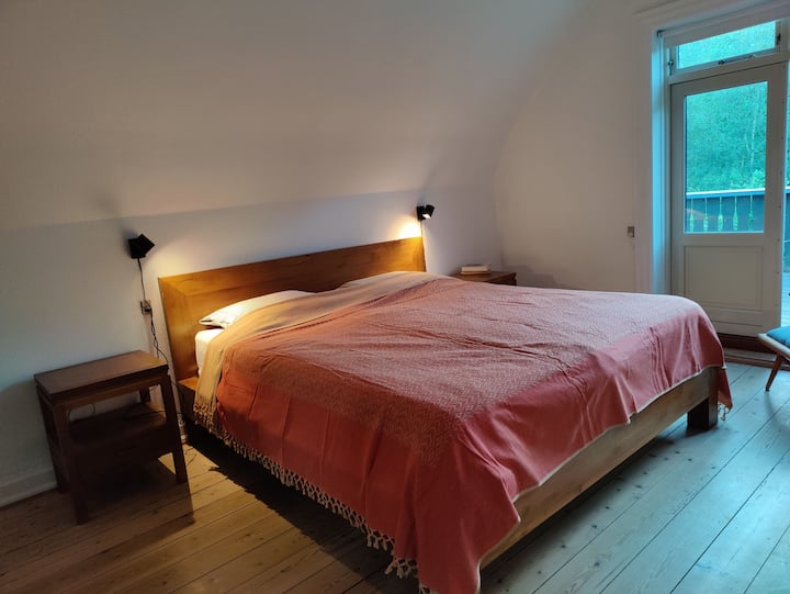 Dormitorio con cama doble grande en el primer piso con acceso directo a la terraza de la azotea.