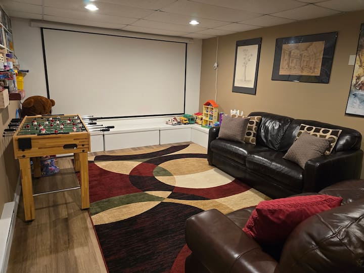 חדר בידור ייעודי עם מסך מקרן גדול, ספות נוחות ושולחן פוטבול. מתאים לערבי סרטים, משחקים ומנוחה.