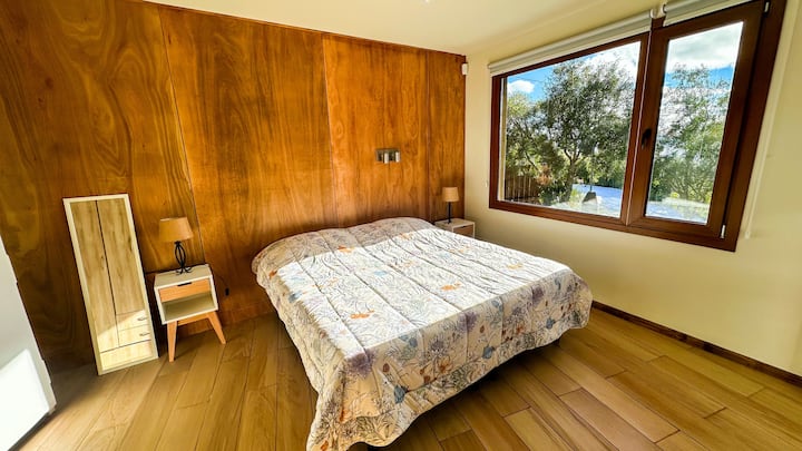 غرفة نوم رئيسية كبيرة في الطابق الأرضي، مع سرير مزدوج بحجم كوين.