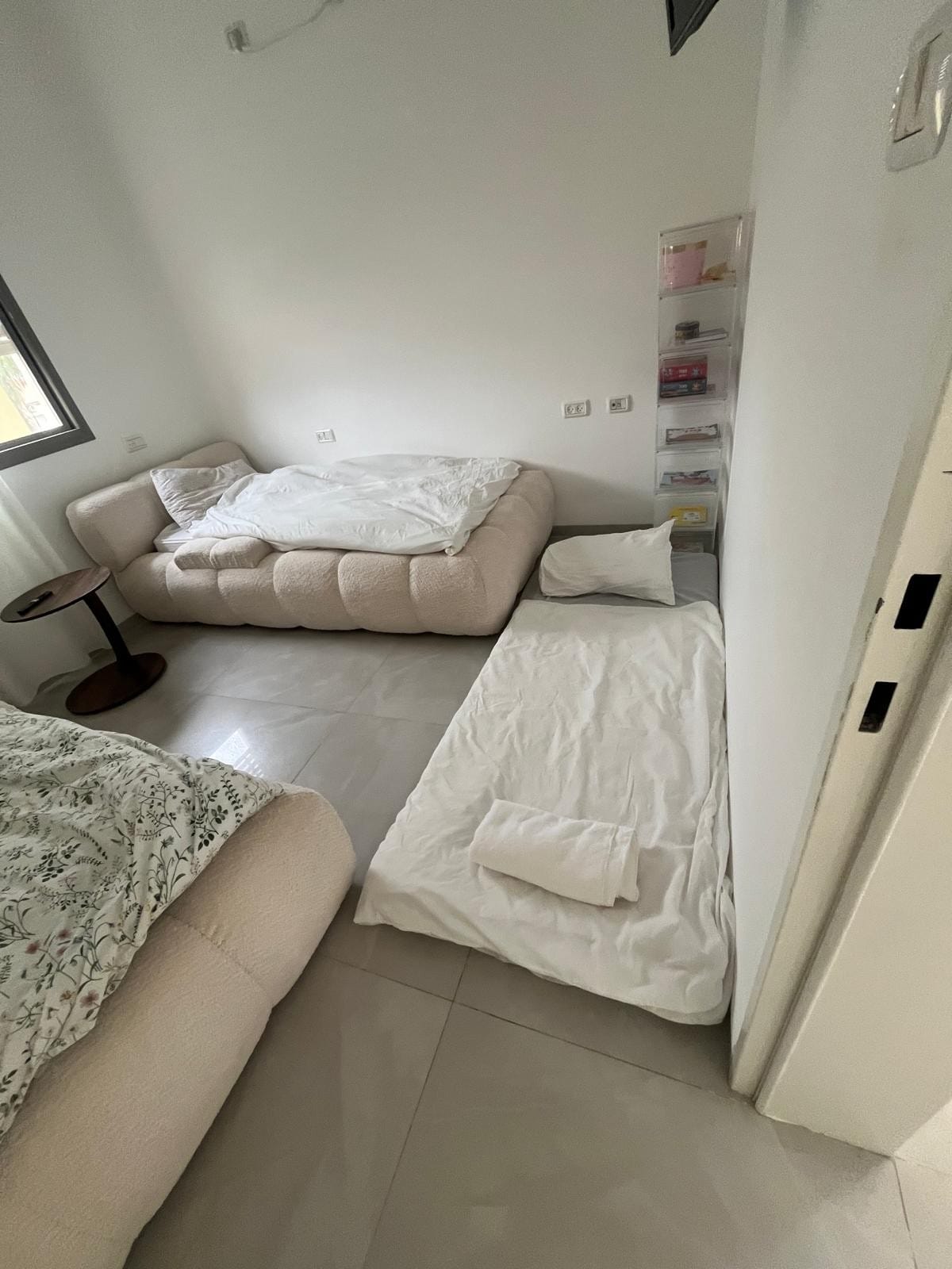 El segundo dormitorio tiene dos camas individuales y es posible colocar un colchón individual en el piso. Todas las camas tienen un juego completo de ropa de cama y toallas de acuerdo con el número de huéspedes en la habitación. Una mesa entre las camas.