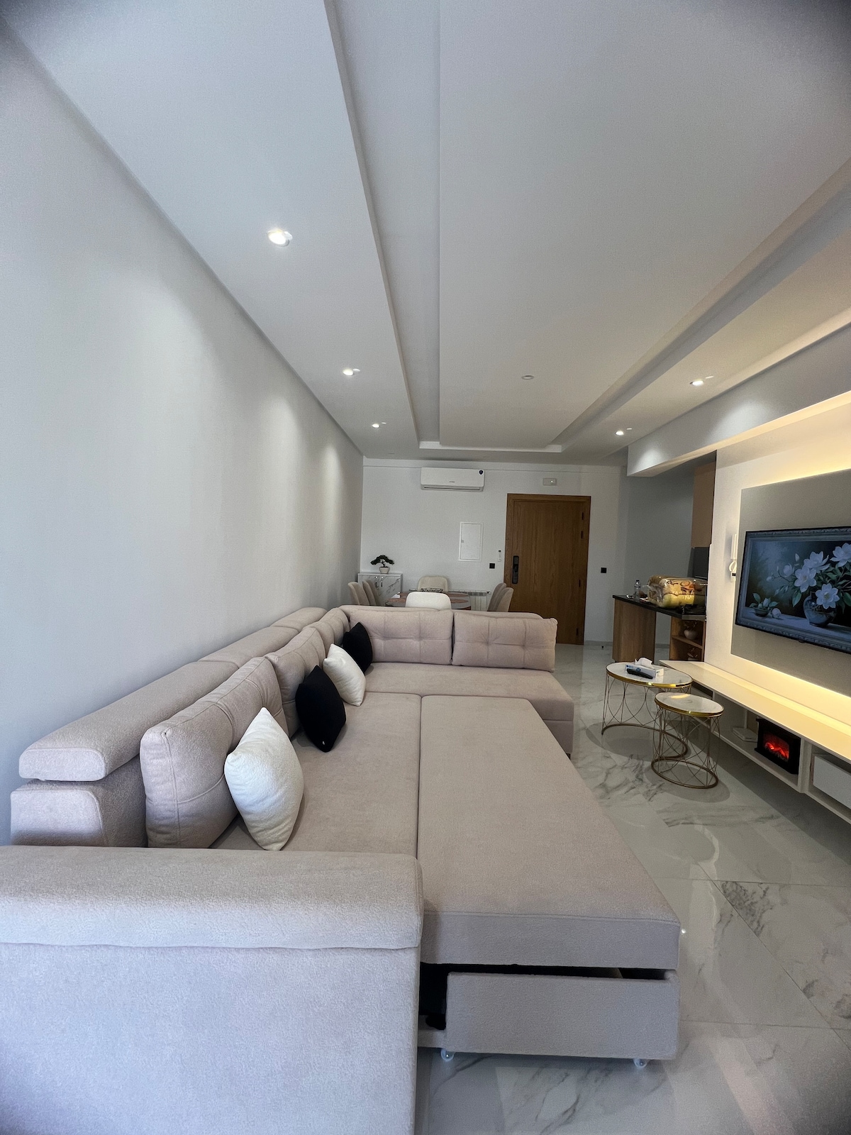 Amplio salón con sofá esquinero convertible en cama doble (sofá cama), ideal para dos personas. Equipado con un gran televisor de pantalla plana, aire acondicionado y una zona de comedor agradable. Perfecto para relajarse después de un día en la playa.