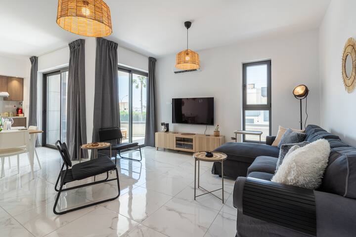 Pumzika katika sebule yetu yenye starehe, iliyo na viti vya kifahari, mapambo yenye joto na mwanga wa kutosha wa asili. Ni mahali pazuri pa kupumzika, kusoma kitabu, au kufurahia filamu baada ya siku ya kuchunguza.