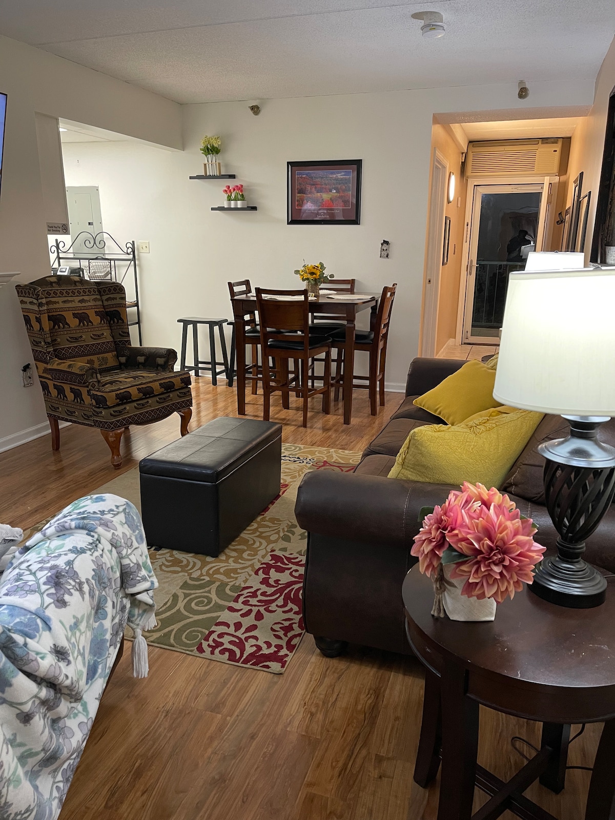 Inviting living room with glass door views, smart TV with cable box, cozy dining space.