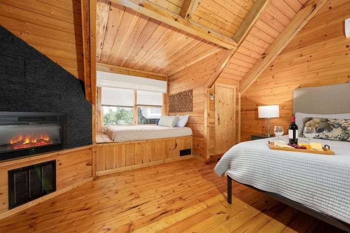 საძილებელი ოთახი კოტეჯში, რომელშიც არის ორი საწოლი, მყუდრო ბუხარი და ხისგან დამზადებული ინტერიერი. იდეალურია წყვილებისა თუ ოჯახებისთვის, ასევე, სმოუკის მთებში დასასვენებლად, სევიერვილის მახლობლად.