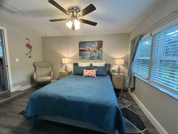 חדר שינה קווין עם שידה וטלוויזיה חכמה.