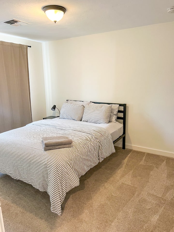 Bedroom 3 has a queen bed, blackout drapes, a small dresser, and hanging rod in the closet. 