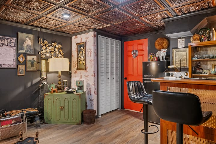 The Velvet Antler, a hidden basement speakeasy with a private bar, lounge seating, and theatrical folk décor.
