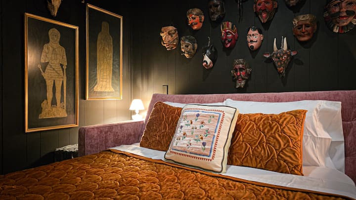 Queen sofa bed in the Velvet Antler speakeasy — plush linens, rich velvet textures, and moody lighting for a cozy, character-filled sleep space.