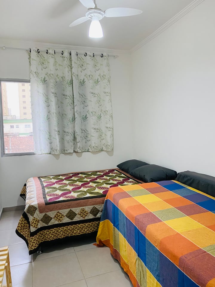 Una cama doble, una cama individual y dos colchones adicionales. 
Habitación espaciosa con ventilador de techo.