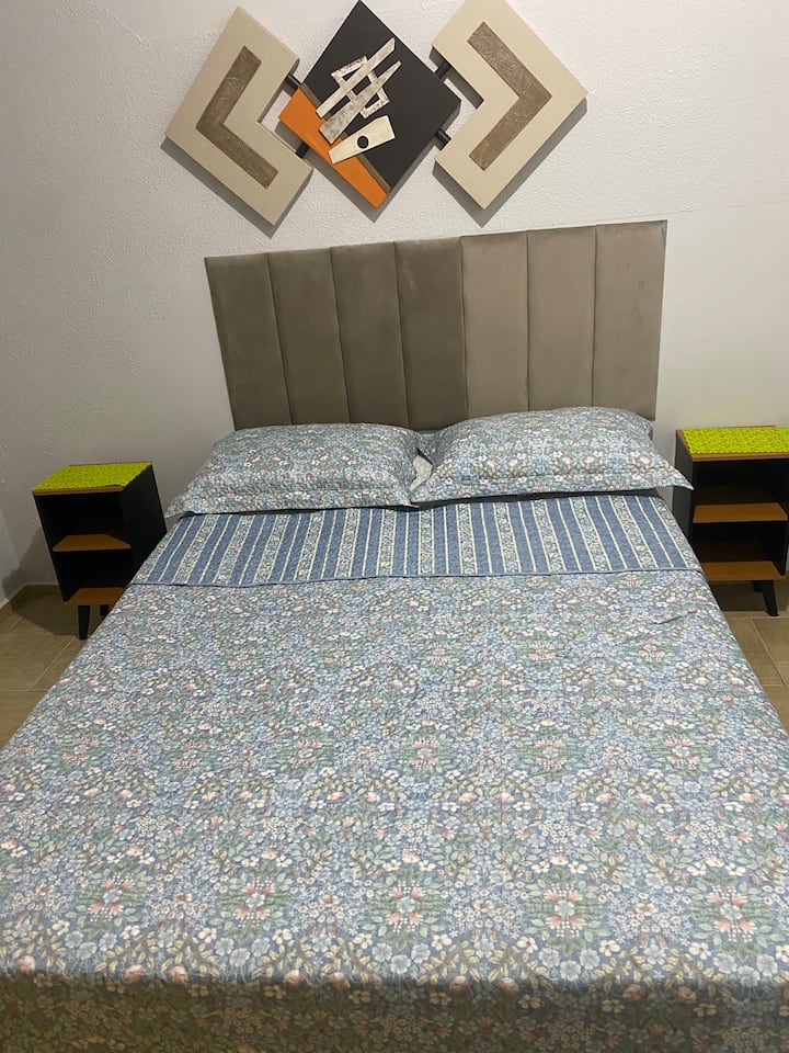 غرفة نوم مزدوجة مع خزانة ملابس، تحتوي على ملاءات ومناشف وبطانية ولحاف 