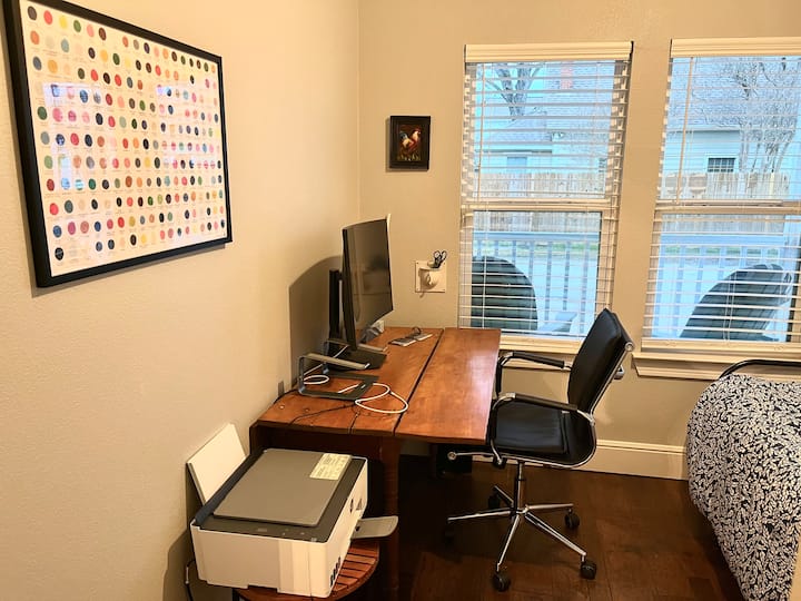 חלל משרדי נוח עם מסך זמין, מדפסת אלחוטית, מעמד למחשב נייד וכיסא שולחן מתכוונן. החדר הזה נמצא בקומת הקרקע.