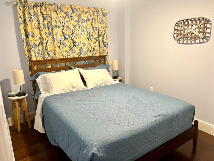 חדר שינה בקומת הקרקע. מיטת קווין סייז עם מזרן נוח חדש של Novaform. בכל שולחן ליד המיטה יש מנורה עם מטען משולב לטלפון. ארון גדול, חדר רחצה מלא ליד. 