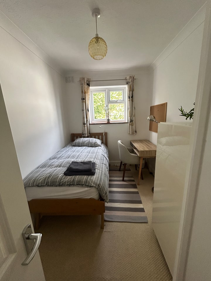 Jednolôžko, pracovný priestor a úložný priestor na oblečenie.