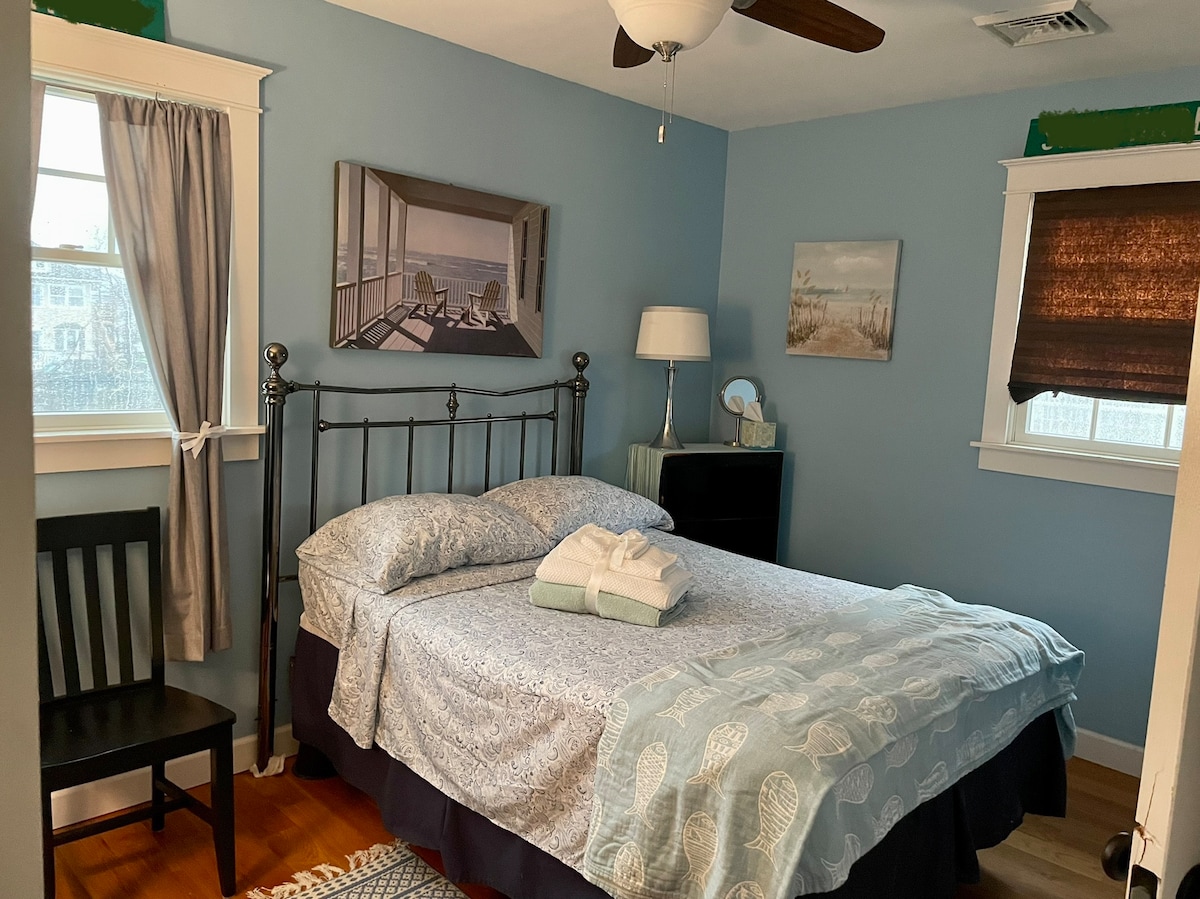 Ce N'EST PAS un lit queen size. Il s'agit d'un lit double/double romantique confortable dans une chambre 9x12, avec deux fenêtres, des stores qui assombrissent la pièce, un placard avec des cintres et des couvertures et des oreillers supplémentaires. 
