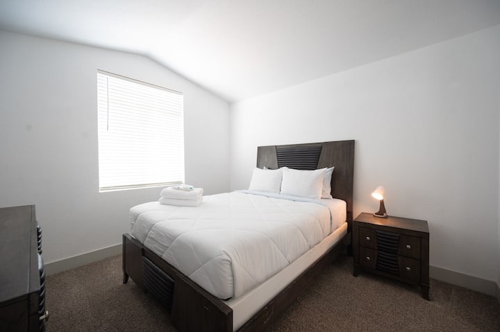 Оваа пријатна спална соба може да се пофали со плишан кревет со свежа постелнина и стилска ноќна масичка. Природната светлина се протнува низ прозорецот, засилувајќи ја спокојната атмосфера.