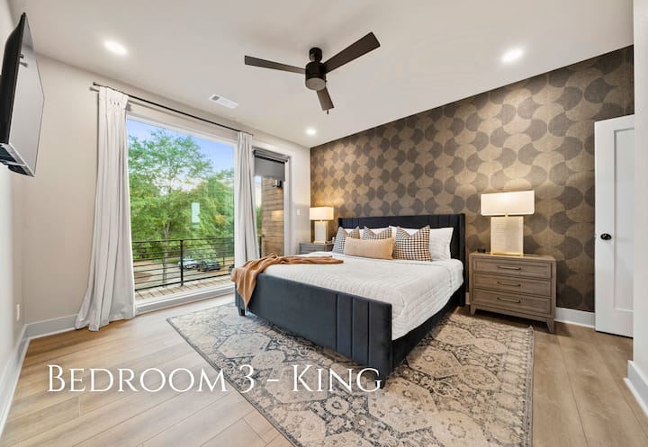 The king-sized bed, dressed in luxurious bedding and complemented by chic pillows, exudes comfort and elegance.