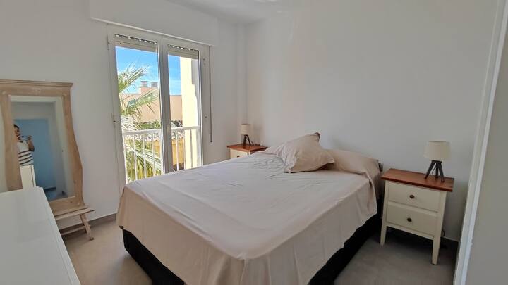 Dormitorio de matrimonio, con balcón y vistas al mar desde la cama. Cuenta con cajoneras,  amplio armario y ventilador de techo.