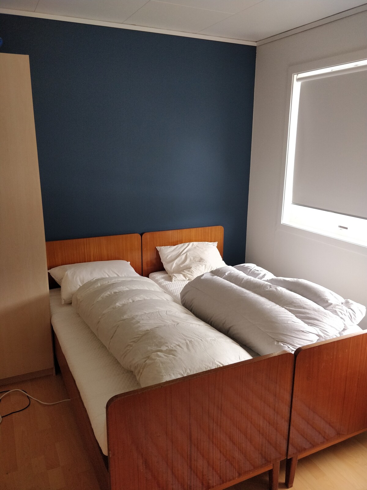 Dos camas individuales, ambas han recibido un nuevo cubrecolchón.