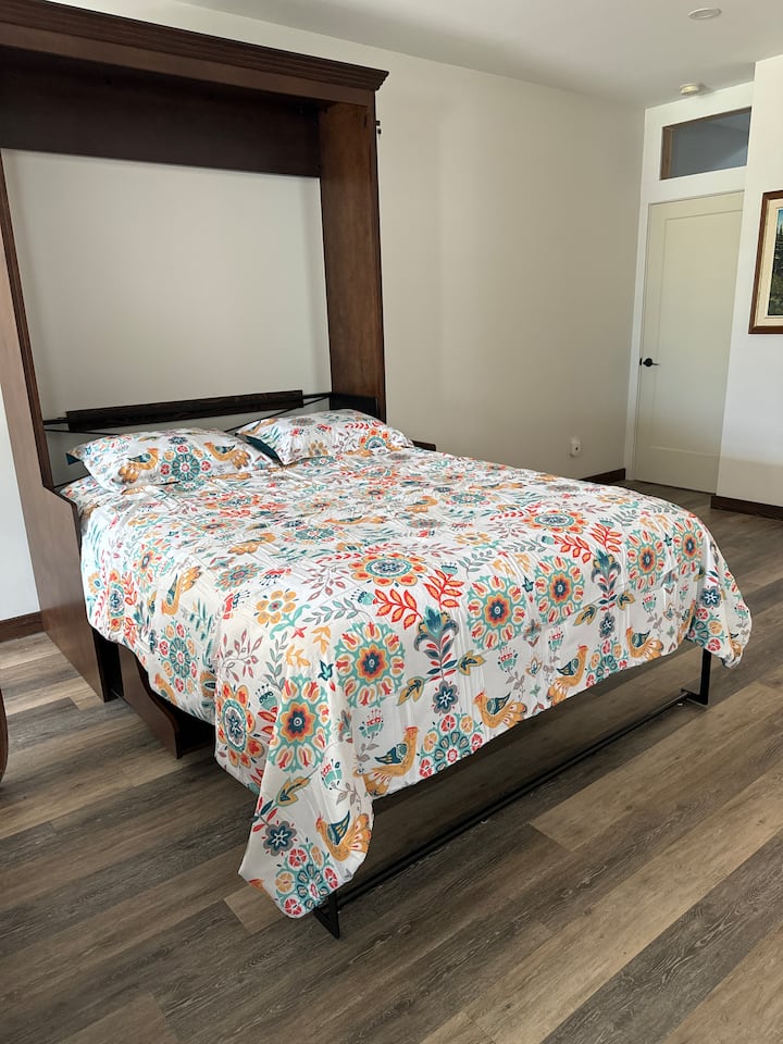 Murphy-bed in de grote open woonkamer. Hetzelfde geldt voor een bureau als het niet in gebruik is.