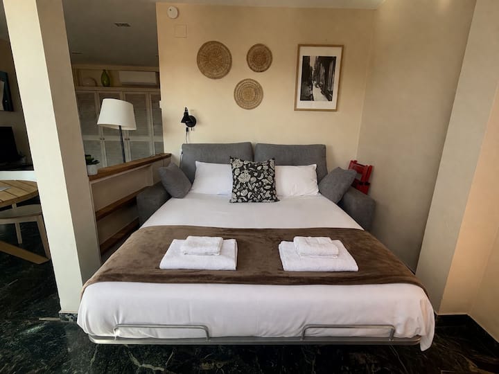 El salón tiene una distribución en L que crea un espacio independiente donde se encuentra el cómodo sofá cama. El colchón, renovado recientemente y de buen grosor, ofrece un descanso confortable para un adulto o dos adolescentes.
