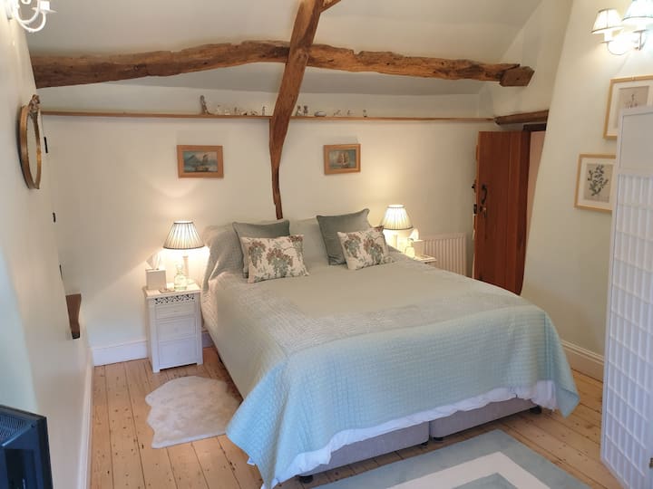 Charaktervolles Schlafzimmer mit Balken. Kingsize-Bett, kann zu zwei Einzelbetten gemacht werden.  Fernseher im Zimmer.  Dusche mit Drench-Kopfdusche.