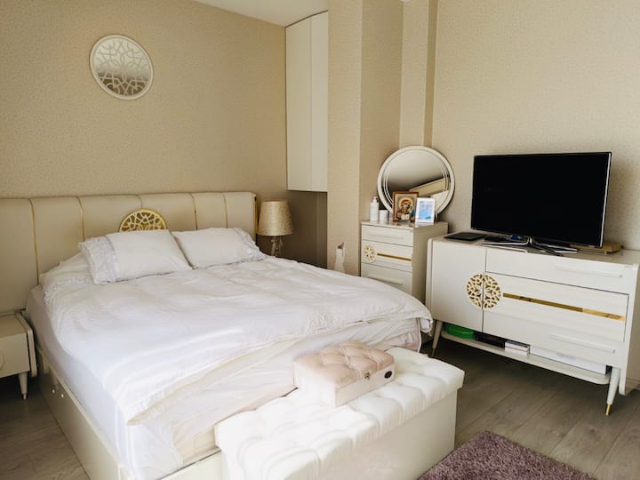 Amplio dormitorio principal con una cama grande, cómoda y armario para un amplio almacenamiento. Disfruta de la luz natural que entra por las ventanas, relájate con la televisión y disfruta de la comodidad durante todo el año con el aire acondicionado.