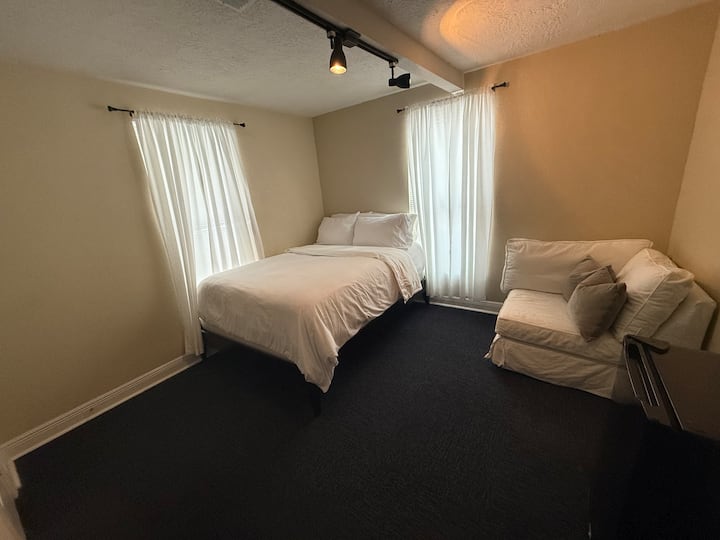 Dormitorio #1 con cama queen,  gran y cómodo sofá de amor de esquina