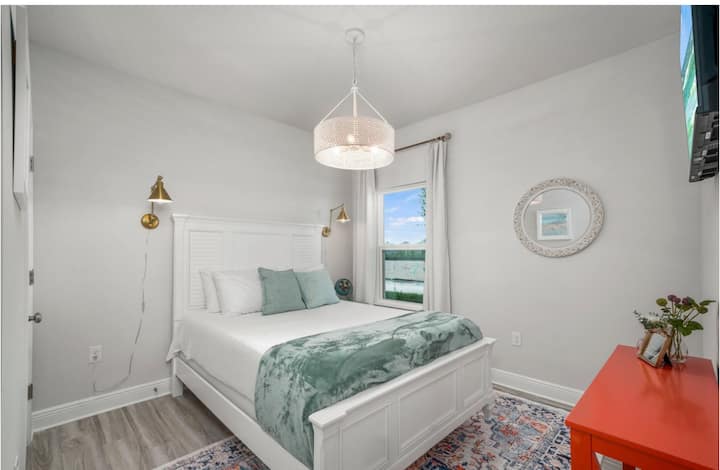 מיטת קווין סייז עם טלוויזיה חכמה, מתלה מזוודות וארון. נוף לצד הרחוב.