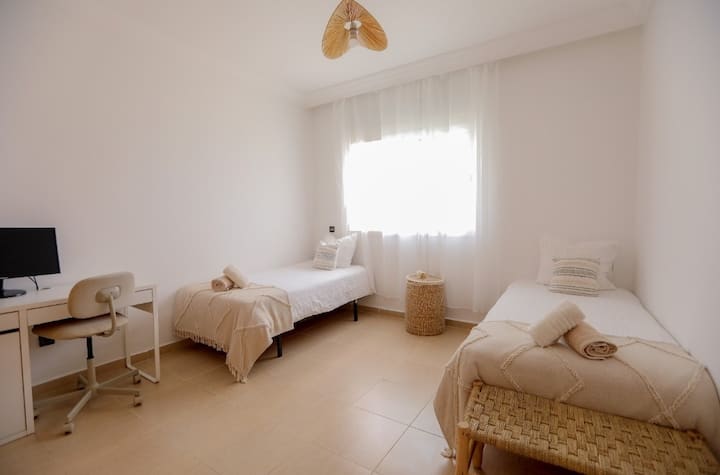 Udobna spavaća soba s dva kreveta za jednu osobu. Praktični prostor za pohranu, prostor za rad.