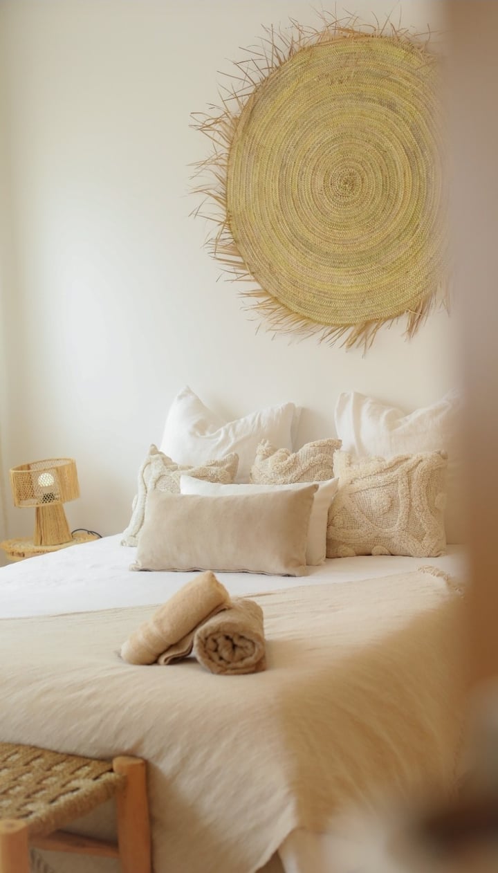 Prostrana spavaća soba s bračnim krevetom i privatnom kupaonicom. Oaza mira uređena u nježnim i prirodnim tonovima.
