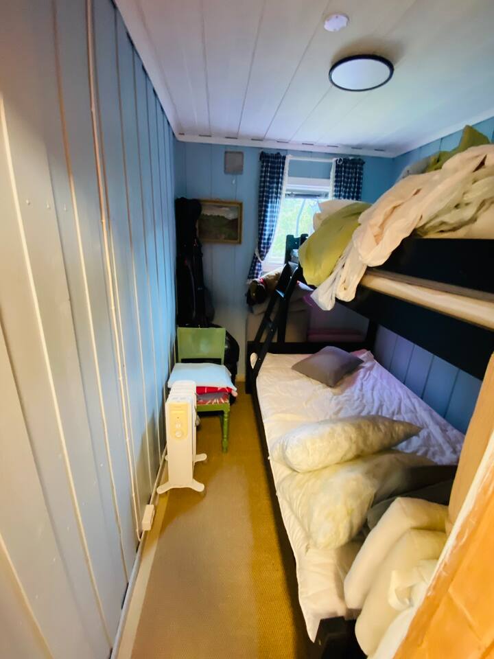 Tu je „rodinná poschodová posteľ“ s miestom pre dve osoby na prízemí a pre jednu osobu na poschodí. Posteľ je široká 120 cm a vysoká 90 cm. 