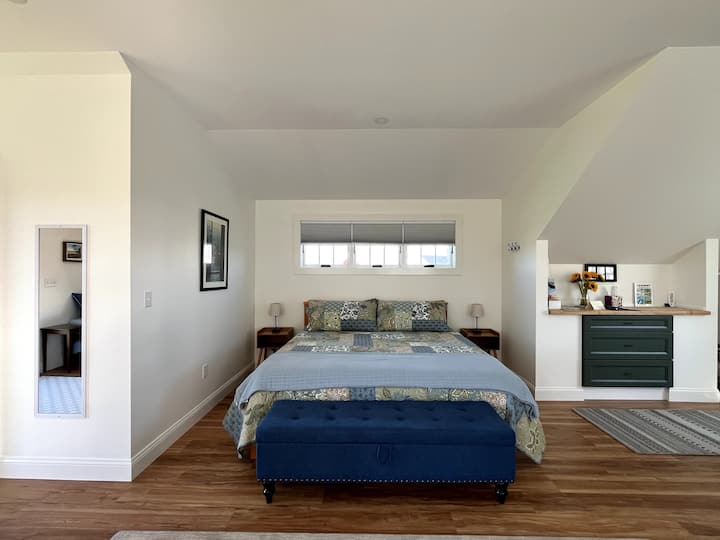 Просторно двойно легло се намира в собствения си кът, заобиколен от чекмеджета за скринове и огледало в цял ръст, монтирано на стената.