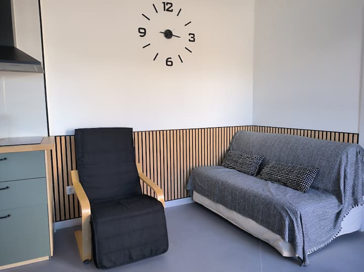 Obývací priestor s 50-palcovou inteligentnou televíziou (prístup k Prime Video a prémiovým káblovým kanálom okrem predplatených kanálov), stoličkou a rozkladacou pohovkou.