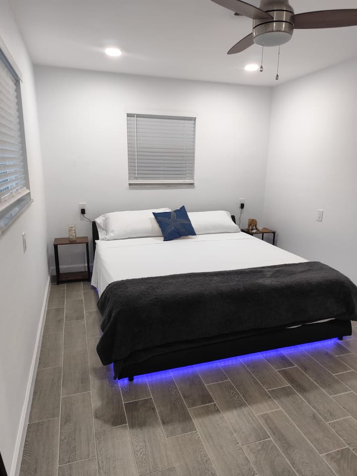 This bedroom is the larger of the two. It has a brand new king bed and mattress, a large dresser and hanging rack. The room has a ceiling fan and blackout curtains. It is adjacent to the the bathroom. This room will easily fit a baby crip or playpen