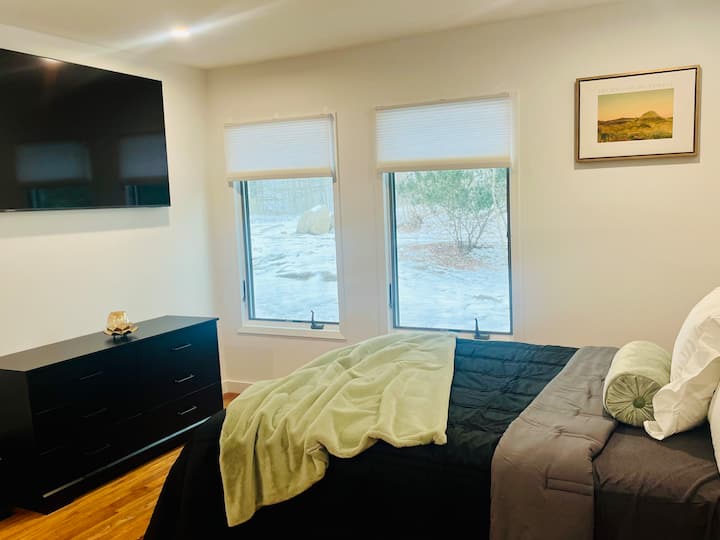 Suitë e vogël me një krevat dopio "queen" dhe pamje nga oborri i pasmë, televizor inteligjent, hapësirë dollapi dhe një kotësi të integruar.