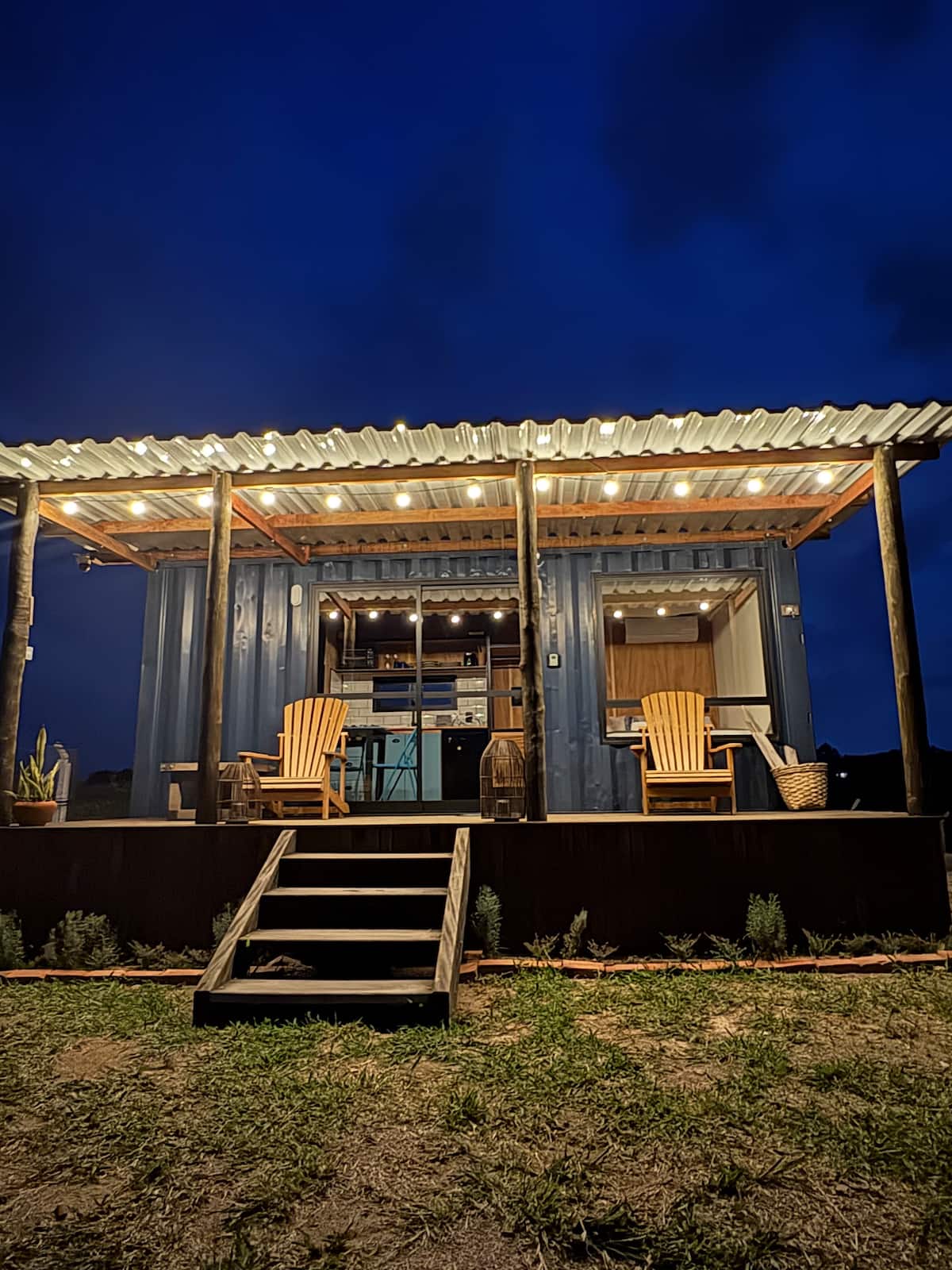 Fachada da cabana iluminada ao anoitecer