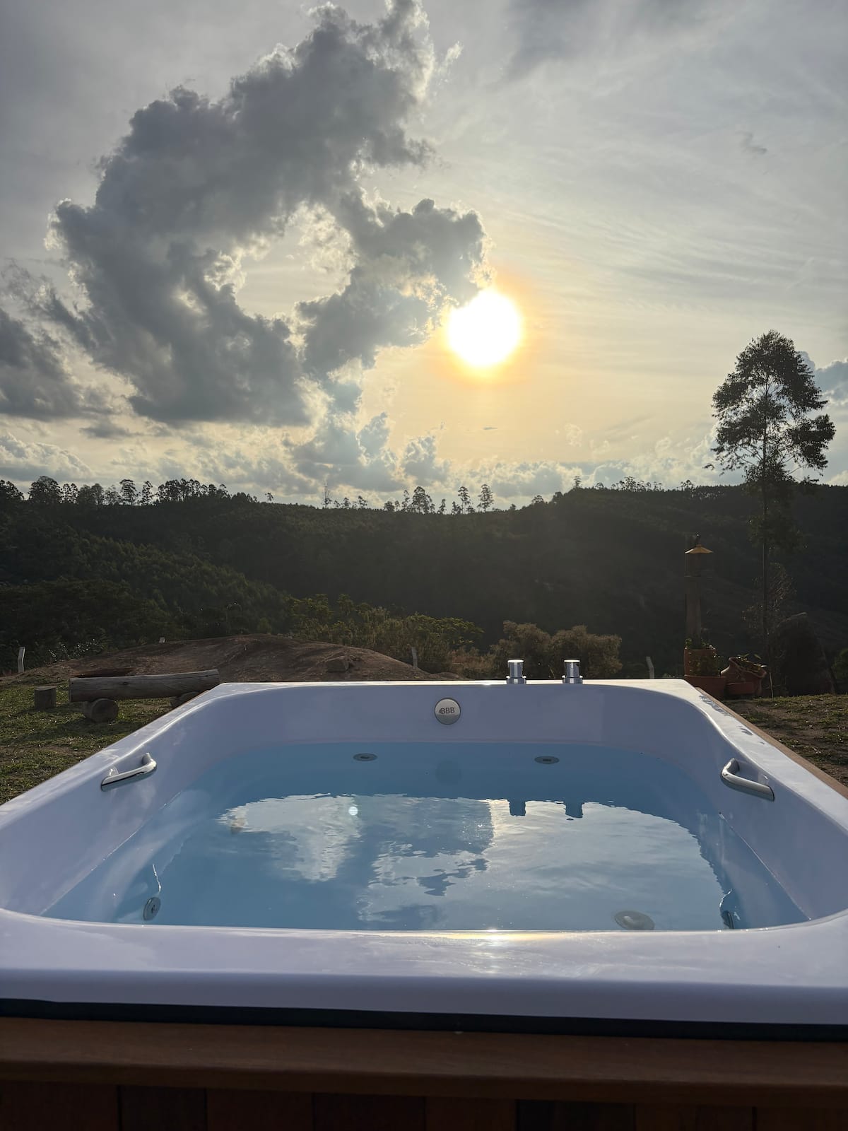 Jacuzzi privativa da cabana com o sol se pondo sobre o vale