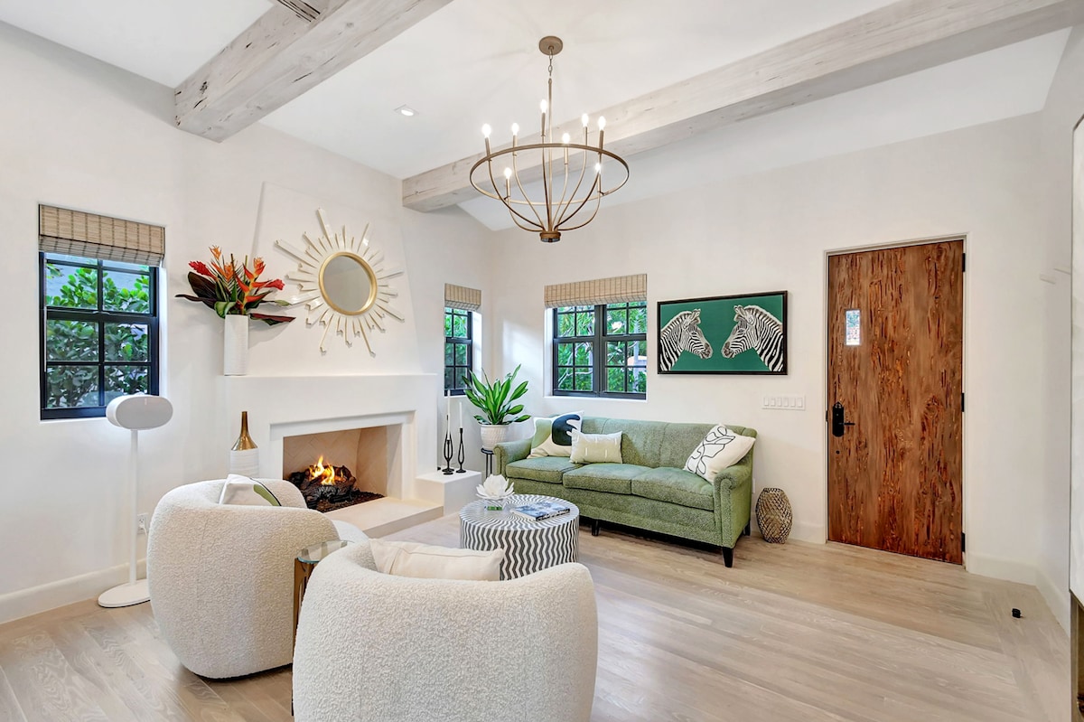 Living room centered on the gas fireplace, with pecky cypress entry door and exposed beam ceilings.