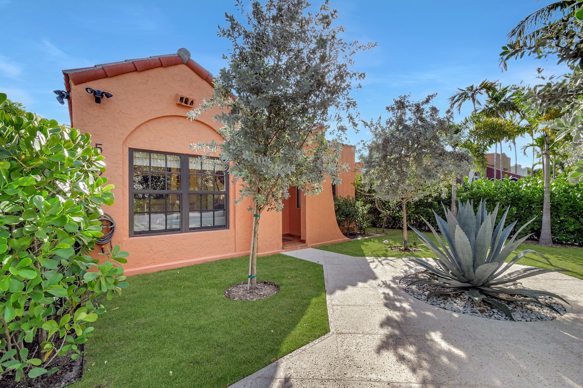 Terracotta walls, steel-framed windows, and a canopy of buttonwood trees frame the approach to The Agave House.