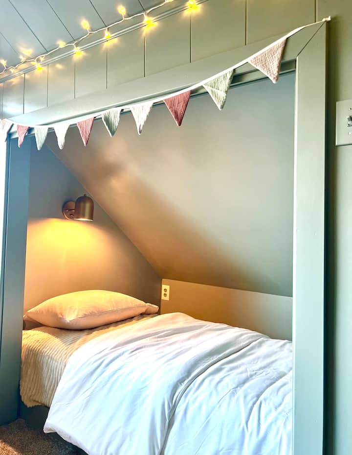 Habitación apta para niños ubicada junto al dormitorio principal. Con 2 camas individuales, TV y espacio de juego, sofás y puf. 