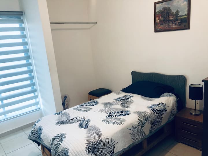 Acogedora recámara con cómoda cama individual y cobija adicional, diseñada para brindarte un descanso placentero.