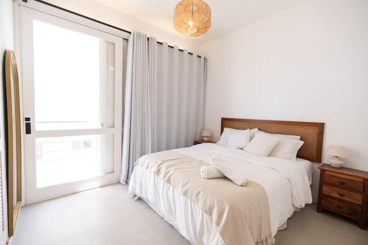 חדר שינה עם מיזוג אוויר, מרפסת ומיטת קווין סייז.