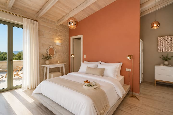 Upper Floor - Master Bedroom 2 with king-size bed, en-suite bathroom, and access to a charming terrace shaded by a centuries-old olive tree.
