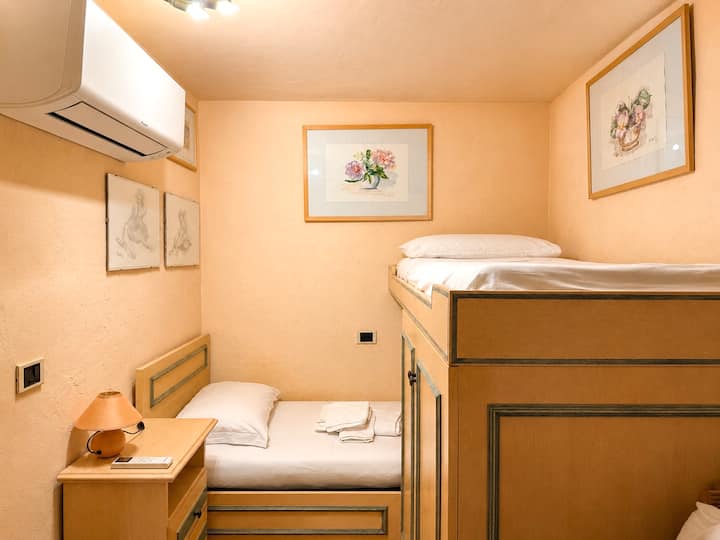 Piccola cameretta con letto a castello, cassettiera e armadi. Dimensione letti: 183 cm x 80 cm.