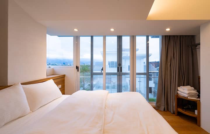 A soft queen bed welcomes the morning light and waking up is a healing.