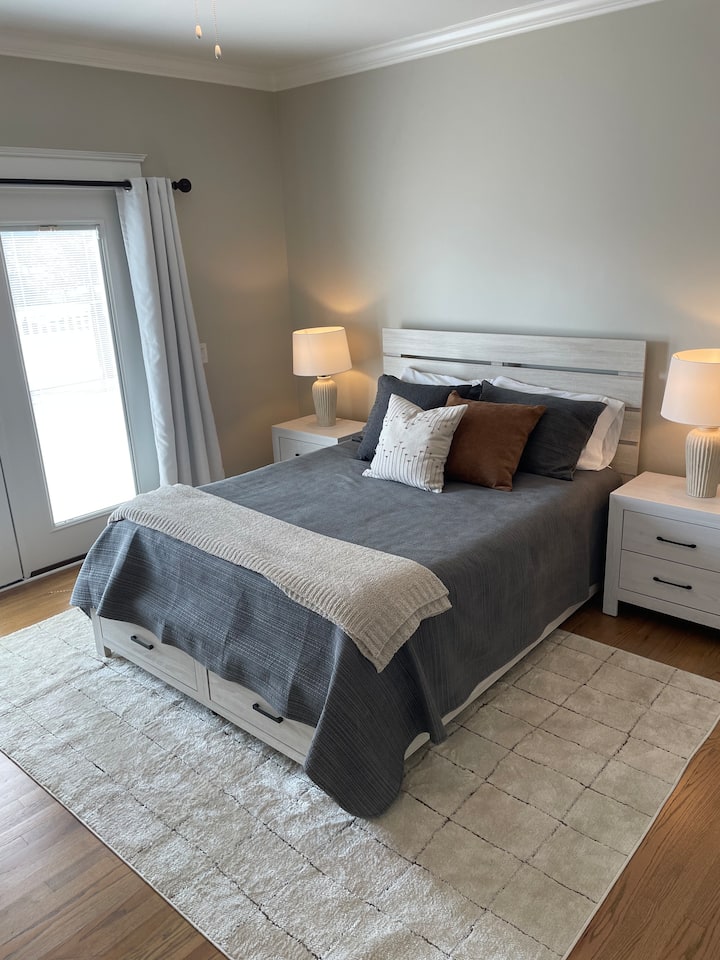 Guest bedroom with queen bed, walk in closet, private bathroom vanity and French doors leading to outside deck. 